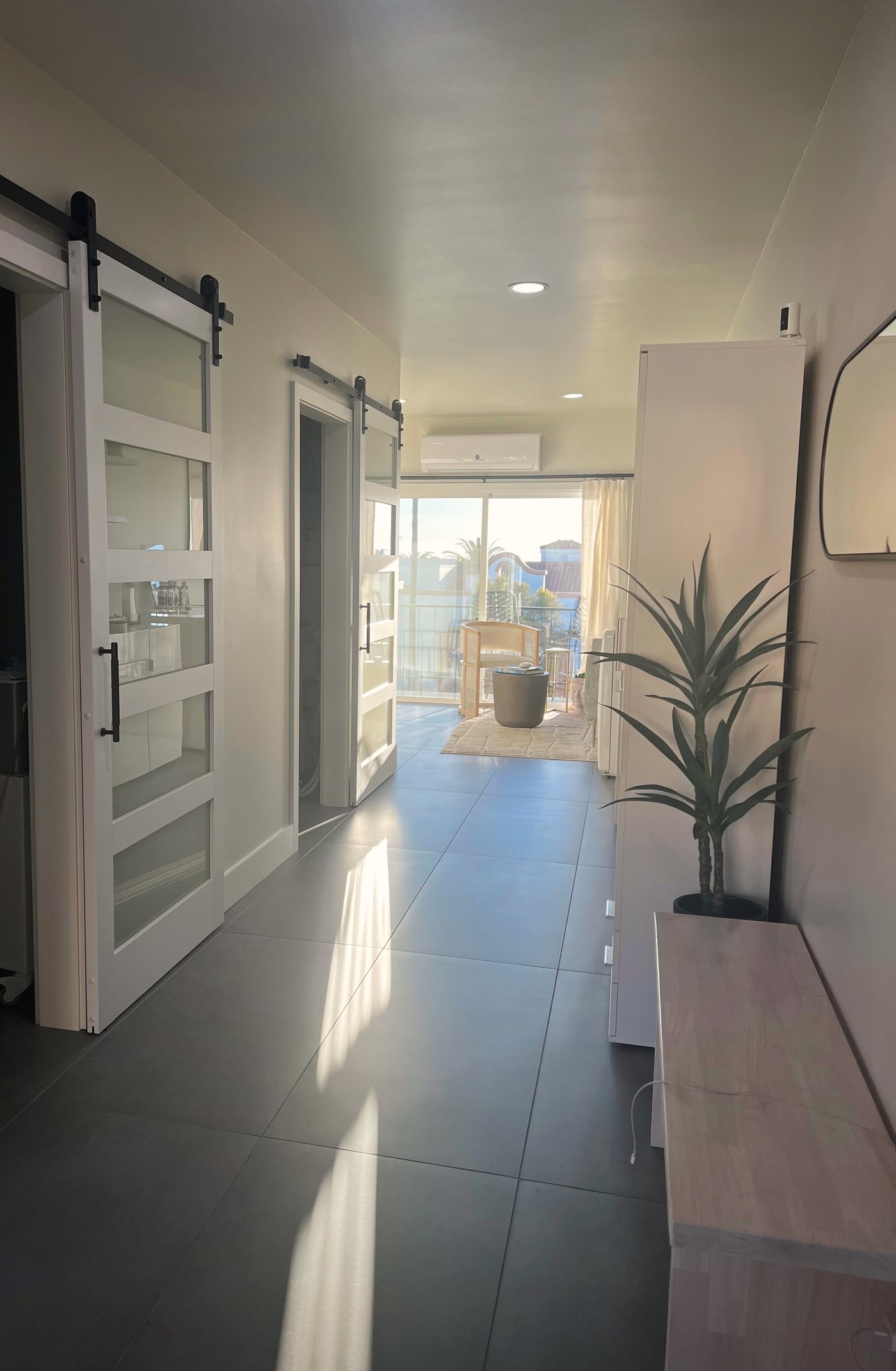 The hallway at Skin Restore, San Clemente, looking toward the back window and balcony with palms beyond